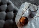 Capitonné leather pouf in Slate Lust color next to Passenger coffee table - BertO
